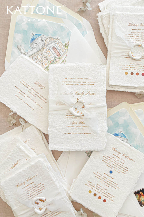 Luxury handmade cotton paper wedding invitation with deckled edges and gold typography, styled with wax seal, vellum wrap and watercolor Greek church envelope liners.