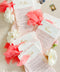 Bring a burst of color and elegance to your table setting with our colored handmade paper wedding menus, crafted from luxurious 100% cotton rag paper. These exquisite menus feature soft blush-pink tones, deckled edges, and gold foil calligraphy, creating a romantic and elevated aesthetic for any celebration. Each menu is finished with a vibrant coral silk ribbon and personalized name tag, combining artistry and function by doubling as both a menu and a place card.
