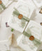 These handmade paper engagement invitations are a true keepsake for life’s most meaningful moments. Printed on luxury deckled-edge cotton paper, each piece showcases the soft texture and organic edges that make handmade paper so timeless and special. Adorned with watercolor botanical illustrations in gentle sage and blush tones, the design radiates natural elegance. The suite is finished with a translucent green silk ribbon and wax seal featuring the couple’s monogram.