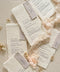 These handmade paper wedding menus embody the essence of soft romance and fine art elegance. Crafted from luxurious 100% cotton rag paper, each piece features delicate deckled edges and a naturally soft texture that enhances its artisanal appeal. The minimalist typography is printed in rich, elegant ink, paired with a vellum-inspired place card and silky blush ribbon, creating a layered and ethereal look perfect for modern romantic tablescapes.