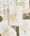 Handmade cotton paper wedding invitation suite with deckled edges, sepia floral design, sheer ivory silk ribbon and coordinated botanical envelope liners.