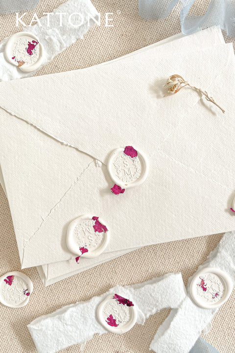 Finish your stationery with timeless elegance using these handcrafted white wax seals. Featuring a soft, creamy white tone with delicate pressed petal accents, each seal adds a refined, romantic detail that feels both modern and heirloom-inspired. Designed to complement handmade paper, fine art envelopes, and silk ribbons, these wax seals are perfect for weddings, baptisms, christenings, and luxury correspondence.
