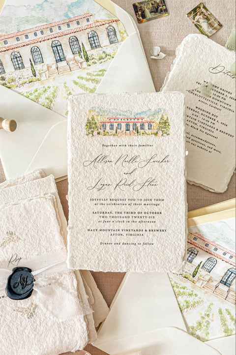 Luxury handmade paper wedding invitation suite featuring deckled-edge cotton paper, custom venue artwork, ivory envelopes, chiffon ribbon, and wax seal styling.