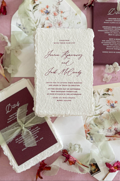 Luxury handmade cotton paper wedding invitation with deckled edges styled with burgundy details cards, sage silk ribbon and botanical watercolor envelope liners.