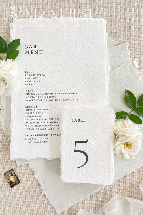 These minimalist handmade paper table numbers are crafted from premium deckle-edge cotton paper, offering a refined, modern aesthetic for timeless wedding décor. Designed with clean typography and natural texture, each card brings understated sophistication to your reception tables. Perfect for couples who love simplicity, luxury, and organic fine-art styling, these table numbers blend effortlessly into any elevated event palette.