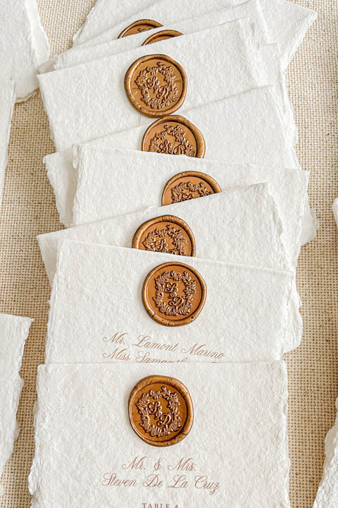 Create an elegant, heirloom-inspired tablescape with our handmade paper place cards, each finished with a luxurious bronze wax seal and finely printed guest names. Crafted from artisan deckled-edge cotton paper, these wedding place cards add a refined, old-world charm to any celebration. Perfect for classic, vintage, or fine-art events where every detail matters.