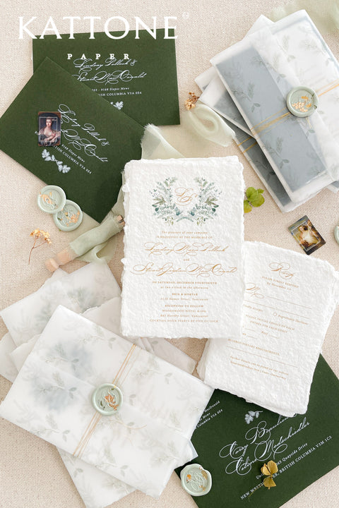 Set a festive and romantic tone for your winter celebration with this exquisite wedding invitation suite. This collection features a beautiful Christmas watercolor monogram of your initials, creating a personalized and seasonal touch. Each invitation is elegantly enclosed in a translucent vellum jacket and sealed with a custom wax seal that includes a delicate golden leaf, adding a luxurious and elegant finish that your guests will adore.