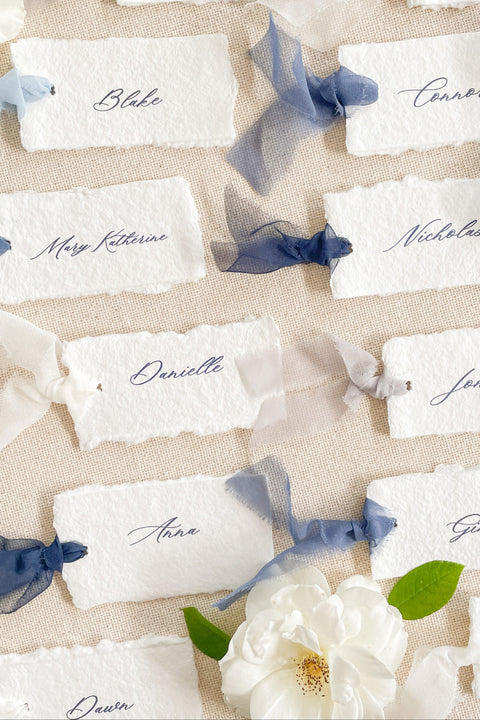 Add soft, romantic detailing to your tablescape with our silk ribbon handmade paper place cards, crafted from premium cotton rag paper and finished with naturally torn deckled edges. Each name tag is threaded with airy, hand-dyed silk ribbon and printed in elegant calligraphy, creating a luxurious fine-art look for weddings, rehearsal dinners, and intimate celebrations. These artisan-crafted cards bring movement, texture, and timeless beauty to your event design.