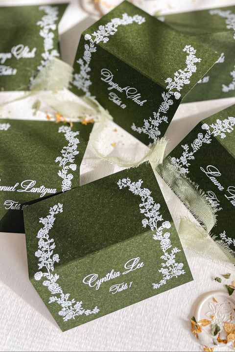 Elevate your tablescape with our elegant forest green place cards featuring delicate white floral illustrations and refined handwritten-style lettering. Crafted on premium cardstock, each folded card brings depth, contrast, and timeless sophistication to your wedding or special event. Perfect for modern, botanical, and luxury themes, these place cards add a polished and cohesive finishing touch to guest seating.