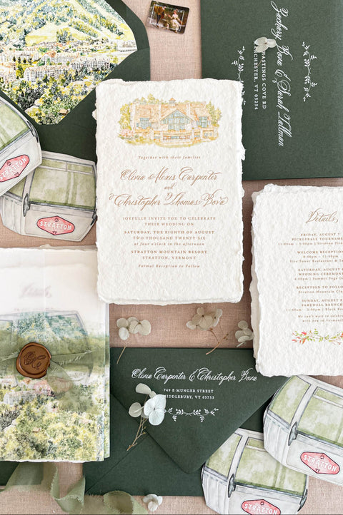 Luxury handmade paper wedding invitation suite featuring deckled edge cotton paper, custom watercolor venue illustration, scenic vellum wrap, sage green envelopes with white ink addressing, and coordinated watercolor stationery details.