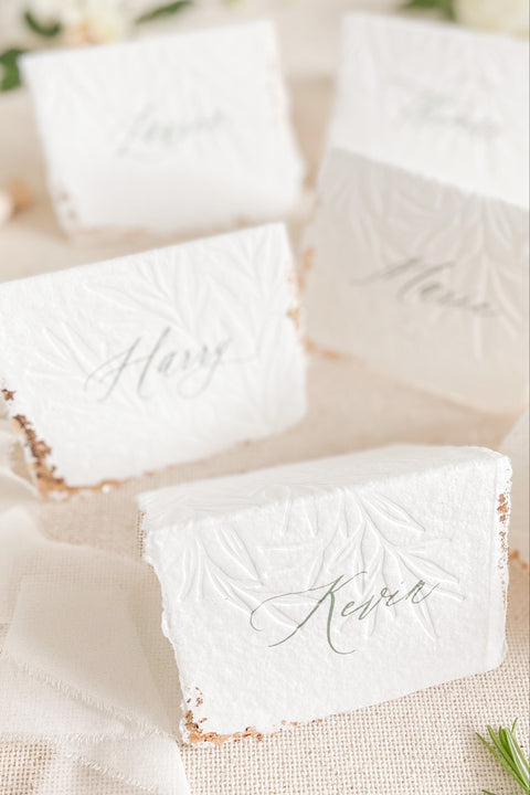 Elevate your table setting with our embossed handmade paper place cards - a luxurious detail for weddings, bridal showers, and upscale events. Each card is crafted from premium cotton rag paper, featuring a soft deckled edge, botanical embossing, and elegant calligraphy. Perfect for seating arrangements, escort cards, or personalized name tags, these artisanal pieces bring a touch of organic elegance to any celebration.