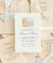 Overhead flat lay of an elegant Sicily-inspired wedding invitation suite featuring ivory handmade paper invitations with coastal watercolor illustrations, champagne envelopes with matching Mediterranean cliff envelope liners, and warm beige handmade paper wedding details cards tied with delicate ivory lace bows. The stationery is arranged on natural linen with soft romantic lace accents.