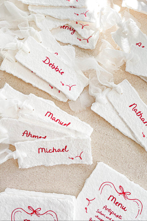 Bring playful charm to your table setting with our handmade paper place cards featuring whimsical red doodles. Each card is crafted from premium deckled-edge cotton paper and finished with delightful hand-drawn accents that add personality and joy to your celebration. Perfect for weddings, parties, kids’ events, or any occasion that calls for a touch of creativity.