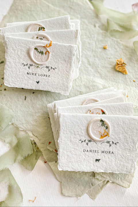 Elevate your table setting with our fine-art handmade paper place cards, each adorned with an elegant pressed-flower wax seal and delicate botanical artwork. Crafted from luxury deckled-edge cotton paper, these name cards bring a romantic, organic charm to weddings, garden celebrations, and intimate events. Their soft sage tones and artisanal texture create an unforgettable, heirloom-quality detail for your guests.