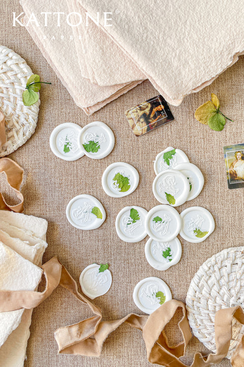Hand-poured wax seals designed to add a timeless, artisanal finish to wedding invitations, envelopes, and fine stationery. Each seal is individually crafted, featuring soft white wax with delicate botanical inclusions for an organic, romantic look that feels both modern and heirloom-inspired. Perfect for elevating wedding suites, bridal stationery, or thoughtful keepsake packaging.