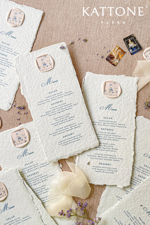 Infuse your reception with timeless artistry through our handmade paper wedding menus, featuring deckled edges, elegant typography, and floral wax seals. Each piece is crafted from soft cotton paper, offering a textured, organic finish that beautifully complements fine-art, garden, or destination weddings. Designed for couples who adore romantic, handcrafted details, these menus transform every place setting into an exquisite statement of elegance.