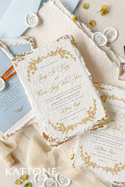 Invite your guests to your special day with the artful beauty of these exquisite handmade paper wedding invites. Perfect for a garden wedding, these invitations feature a delicate golden leaf addition, providing a touch of understated elegance and luxurious shimmer. The tactile and organic feel of the deckle edge paper creates a truly memorable keepsake, setting a romantic and refined tone for your celebration.