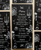 Black wedding menus with whimsical hand-drawn wedding icons and white typography, styled for a modern reception.