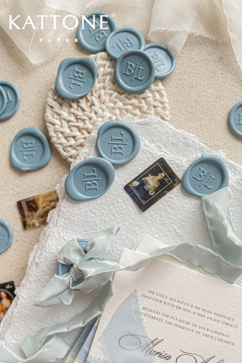 Elevate your stationery with these handcrafted dusty blue wax seals, designed to add a soft, timeless accent to fine art invitations. Each seal is individually poured and stamped with a classic monogram, creating a refined detail that feels elegant, tactile, and intentionally made. The muted blue tone pairs beautifully with handmade paper, silk ribbons, and neutral palettes, making these wax seals a perfect finishing touch for weddings and bespoke paper goods.