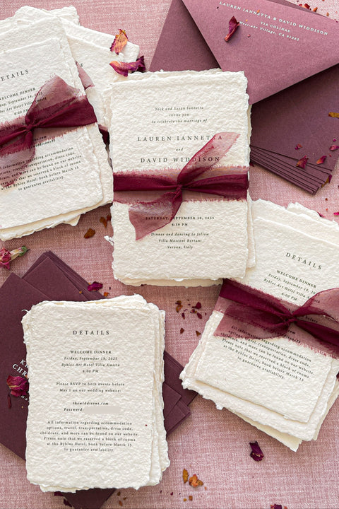 Romantic, rich, and full of timeless charm - this handmade paper wedding invitation suite is the perfect harmony of texture, elegance, and deep color. Each invitation is printed on luxurious cotton handmade paper with naturally deckled edges, exuding an organic and artisanal feel that makes every piece truly one of a kind. The suite is beautifully complemented by deep burgundy envelopes and tied with flowing silk chiffon ribbons in wine red, adding warmth, passion, and sophistication.