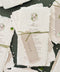 Handmade paper wedding menu with deckled edges and custom watercolor monogram, fine art reception stationery flat lay.