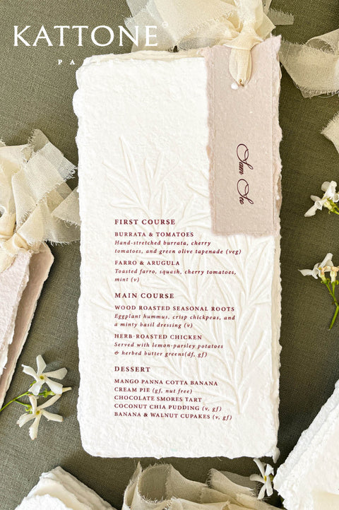 Handmade paper wedding menus with deckle edges, elegant typography, and luxury table styling.