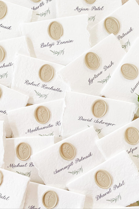 Create a refined and romantic tablescape with our handmade paper place cards, crafted from premium cotton rag paper and finished with soft deckled edges. Each card is adorned with an elegant neutral wax seal and fine calligraphy, offering a timeless accent for weddings, rehearsal dinners, and upscale celebrations. Designed to add texture, charm, and an elevated touch, these artisan-crafted place cards make your seating display truly unforgettable.