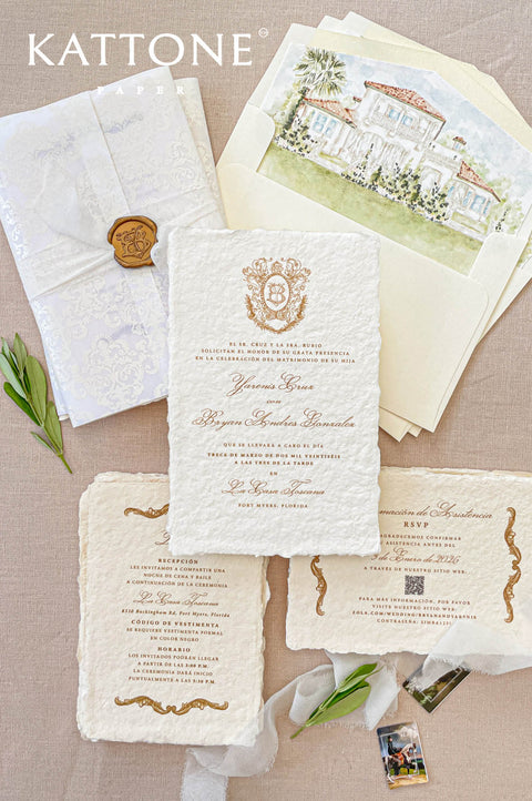 Handmade paper wedding invitation with deckled edges, gold crest monogram, luxury wax seal, fine art wedding stationery flat lay.