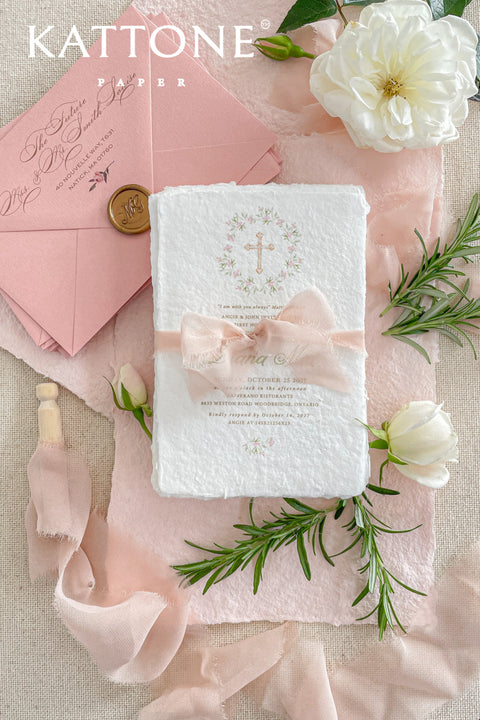 A soft and elegant christening invitation crafted from luxurious handmade paper and finished with a blush chiffon ribbon. Featuring a delicate watercolor floral wreath and subtle Christian cross, this design beautifully celebrates faith, innocence, and new beginnings. Perfect for baptisms, christenings, and church ceremonies, it creates a heartfelt keepsake your family will treasure.