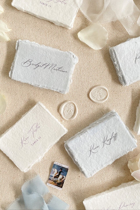 Add a touch of fine-art elegance to your celebration with our colored handmade paper place cards, crafted from premium cotton rag paper and finished with soft, natural deckled edges. Each card features beautifully flowing calligraphy and comes in a curated palette of soft, romantic hues - perfect for weddings, dinner parties, bridal showers, or luxury events. Designed to elevate any tablescape, these artisanal place cards bring warmth, texture, and timeless beauty to your seating arrangements.