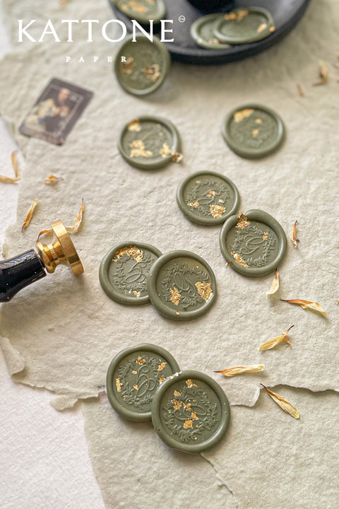 Bring a refined botanical accent to your stationery with these handcrafted botanical wax seals, finished in a soft sage-green ivory tone and delicately embellished with gold leaf. Each seal is individually poured and stamped, creating organic edges and subtle variations that celebrate true artisanal craftsmanship. Designed to complement fine-art paper, neutral palettes, and nature-inspired weddings, these wax seals add an elevated, timeless touch to invitations, envelopes, and curated details.