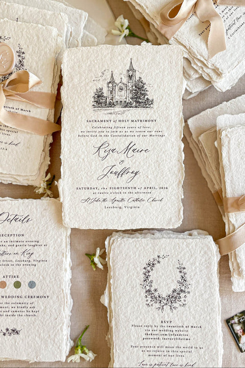 Handmade paper wedding invitations with custom church illustration, deckle edges, silk ribbon, and wax seal details.