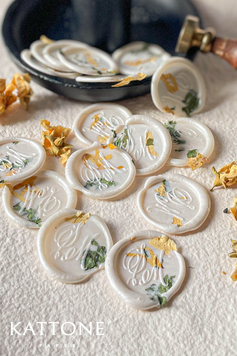 Elevate your stationery with these handcrafted ivory botanical wax seals, delicately infused with pressed florals for an organic, romantic finish. Each seal is individually poured and stamped, creating subtle variations that add character and artisanal charm to wedding invitations, envelopes, place cards, favors, and luxury paper goods. Designed to complement fine-art stationery, these wax seals bring a timeless, nature-inspired touch to any celebration.