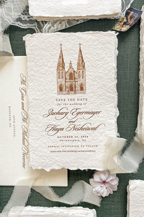 Handmade paper save the date cards with deckle edges and a custom wedding venue illustration.