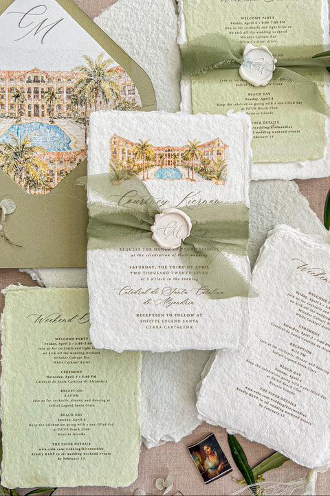 Top-down flat lay of luxury sage green destination wedding invitation suite featuring ivory handmade deckled-edge paper, pale green weekend details cards, watercolor resort illustration, sage silk ribbon, ivory monogram wax seals, and olive green envelopes with tropical watercolor liners