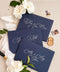 Navy wedding envelopes with white ink address printing, styled flat lay with ivory florals, wax seals, and greenery, perfect for classic and elegant invitation suites.