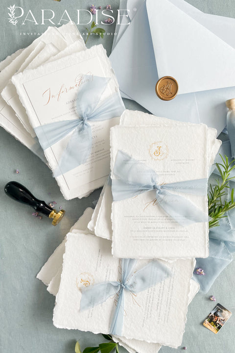 Announce your seaside celebration with a touch of vintage romance and personalization with these unique wedding invitations. Perfect for a beach wedding, this suite is printed on luxurious handmade paper, giving it a soft, textured, and truly premium feel. A bespoke custom vintage letter monogram adds an elegant and personalized touch, while the light sky theme evokes the serene and beautiful atmosphere of the coast.
