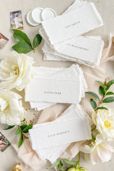 Add refined simplicity to your event with our handmade paper place cards, crafted from premium cotton rag paper and finished with naturally torn deckled edges. Each name tag features minimalist printed lettering and a soft fine-art aesthetic, making them perfect for weddings, rehearsal dinners, intimate gatherings, and elegant celebrations. These artisan-crafted cards bring understated beauty, organic texture, and timeless charm to any tablescape.