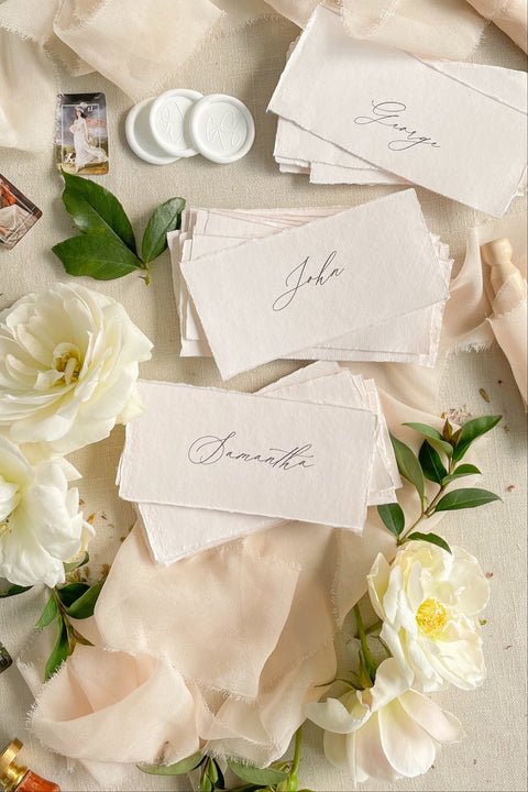 Elevate your event with our handmade paper place cards, crafted from luxurious cotton rag paper and finished with naturally torn deckled edges. Each name tag features elegant calligraphy and a soft fine-art aesthetic, making them ideal for weddings, intimate dinners, bridal showers, and high-end celebrations. These artisan-crafted cards bring refined texture, timeless charm, and a beautifully romantic look to any tablescape.