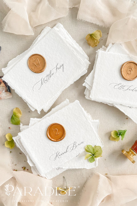 Add an artisanal charm to your wedding tables with our handmade paper place cards, delicately crafted from 100% cotton paper with natural deckled edges. Finished with elegant calligraphy and a wax seal detail, these fine-art cards bring a sense of timeless romance and sophistication. Perfect for luxury weddings, garden receptions, or intimate dinner parties, they seamlessly combine old-world craftsmanship with modern elegance.