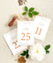 Clean white cardstock paired with rich copper typography creates a beautifully modern yet romantic table number design. Delicate botanical borders add a soft, ornamental touch, giving each card a refined and cohesive wedding-day presence. Perfect for elegant, garden, rustic-chic, or contemporary celebrations, this style blends minimalist clarity with decorative charm.