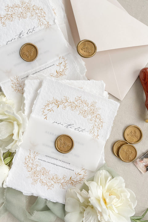 Announce your wedding with timeless beauty through our handmade paper Save the Date cards, featuring an elegant gold floral wreath, vellum wrap, and hand-stamped wax seal. Each card is printed on luxury 100% cotton handmade paper with natural deckled edges, creating a soft, organic texture that exudes fine-art sophistication.