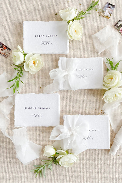 Add refined elegance to your seating display with our handmade paper place cards, crafted from luxurious cotton rag paper and finished with naturally torn deckled edges. Each card features minimalist typography paired with a soft fine-art aesthetic, making them perfect for weddings, intimate dinners, bridal showers, and elevated celebrations. With their organic texture and timeless look, these artisan-crafted cards bring sophistication and effortless beauty to any tablescape.