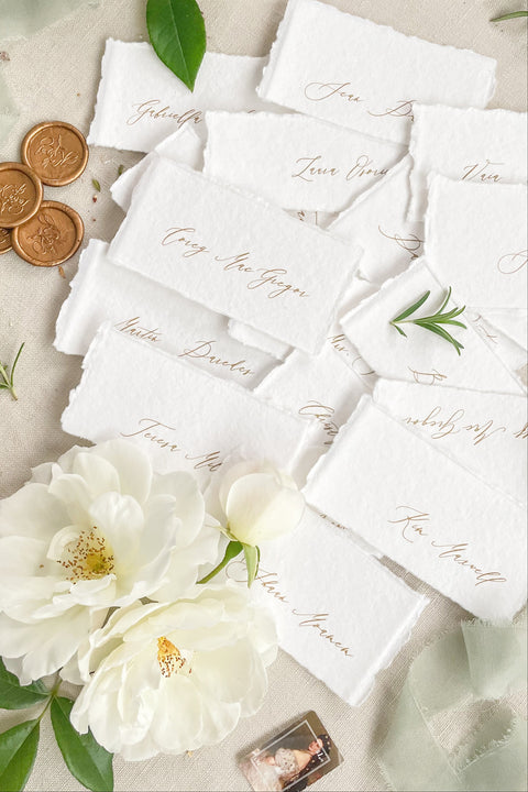 Create a romantic, fine-art tablescape with our handmade paper place cards, crafted from luxurious cotton rag paper and finished with soft, torn deckled edges. Each card features elegant calligraphy, delicate chiffon ribbon, and a timeless organic texture - perfect for weddings, intimate dinners, bridal showers, or upscale celebrations. These artisan-crafted pieces bring softness, refinement, and natural beauty to any seating display.