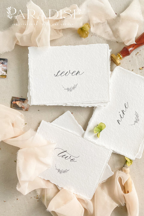 These botanical handmade paper table numbers bring a delicate, organic touch to your wedding tablescape. Hand-torn deckled edges, soft cotton texture, and airy calligraphy pair beautifully with garden, romantic, or fine-art weddings. Each number features a subtle botanical illustration, adding a graceful natural element to your reception styling.