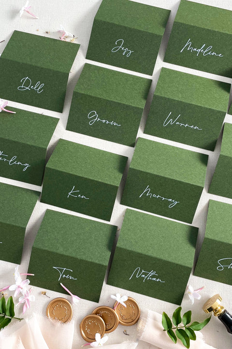 Bring depth, richness, and modern elegance to your tablescape with our forest green place cards, crafted from premium heavyweight cardstock and printed with refined calligraphy. Their deep green tone offers a sophisticated, nature-inspired aesthetic perfect for weddings, dinner parties, winter celebrations, and fine-art events. These cards provide bold contrast and a polished finish, making your seating arrangement both stylish and memorable.