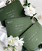 Elegant deep green wedding envelopes with white ink address printing, styled flat lay with wax seals and florals, perfect for modern and classic invitation suites.