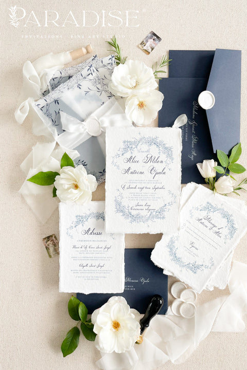 Celebrate your love with elegance and craftsmanship through our handmade blue fine art wedding invitations, featuring deckled-edge cotton paper, soft botanical designs, and luxurious vellum wraps tied with delicate silk ribbon and a custom wax seal. This suite combines timeless artistry with modern sophistication, perfect for coastal, fine art, or destination weddings seeking a romantic and refined aesthetic.