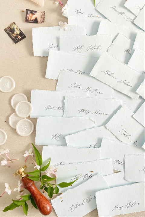Add soft color and fine-art elegance to your event with our colored handmade paper place cards, crafted from luxurious cotton rag paper and finished with naturally torn deckled edges. Each card features refined calligraphy and a subtle organic texture, creating a beautifully romantic detail perfect for weddings, showers, rehearsal dinners, or elevated celebrations. Their artisanal feel and pastel tones bring charm, sophistication, and warmth to any tablescape.