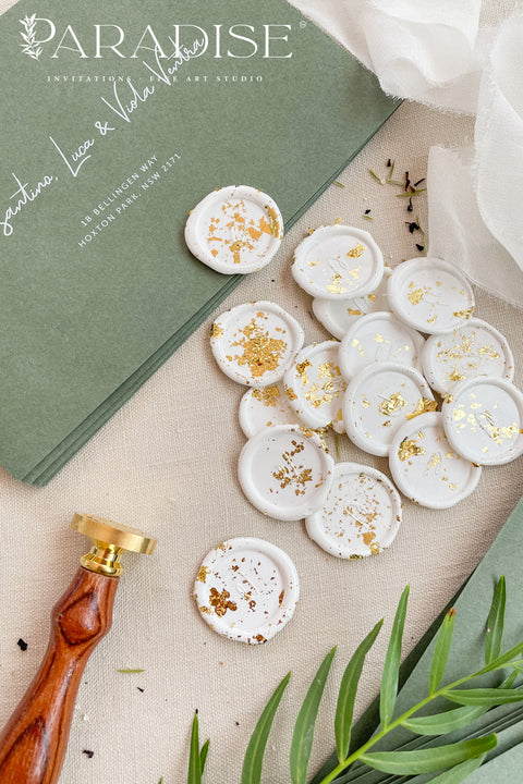 Add a refined finishing touch to your stationery with these handcrafted ivory wax seals, delicately scattered with gold leaf for a soft yet luxurious effect. Each seal is individually poured and stamped, creating organic edges and subtle variations that highlight the beauty of true artisan work. Perfect for wedding invitations, envelopes, menus, or favors, these wax seals bring timeless elegance and a curated, fine-art feel to every detail.